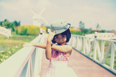 Girl looking away while standing on railing