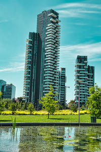 River by modern buildings against sky in city