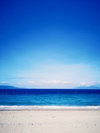 Scenic view of beach against blue sky