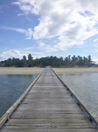 Wooden pier over lake against sky