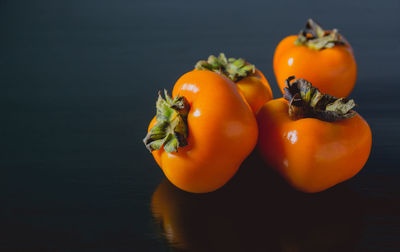 Close-up of orange fruits on table against black background