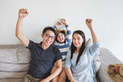 Portrait of happy young couple sitting on sofa