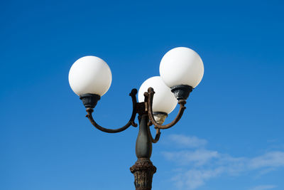 Low angle view of street light against blue sky