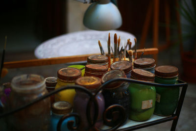 Close-up of various paint brushes and colours on table
