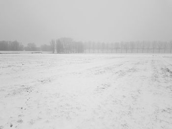 Scenic view of snow covered field against sky