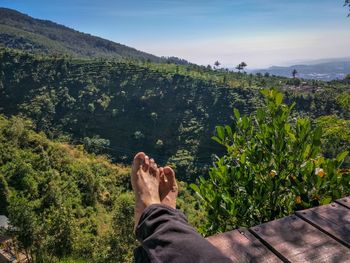 Low section of man on mountain against sky