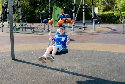 Full length of boy swinging at playground