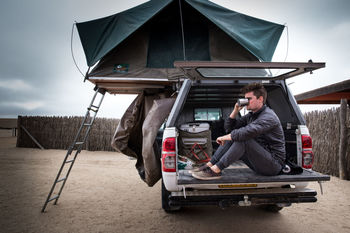 Man sitting in motor home and drinking coffee