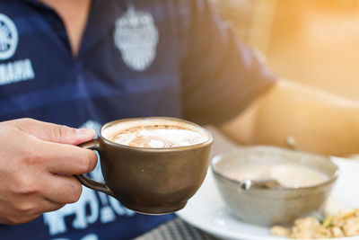 Close-up of man holding coffee cup