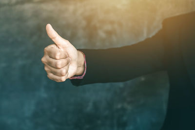 Cropped image of business person showing thumbs up