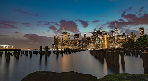Panoramic view of river and buildings against sky at dusk