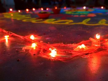 Close-up of lit candles on fire at night