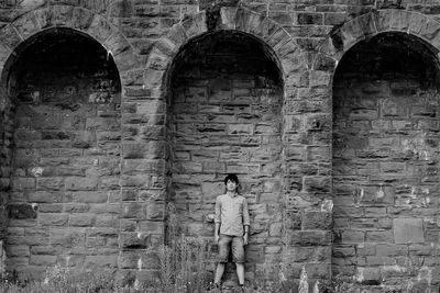 Man standing against brick wall