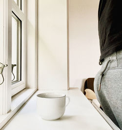 Close-up of woman standing against wall at home