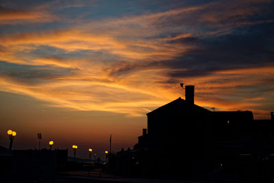 Silhouette buildings against sky during sunset