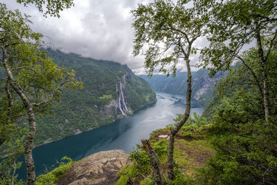 Scenic view of waterfall in forest against sky