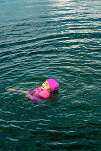 Cute little girl swimming in a lake, happy child, fun in water, summer vacation, holidays