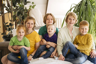 Portrait of happy family sitting on table