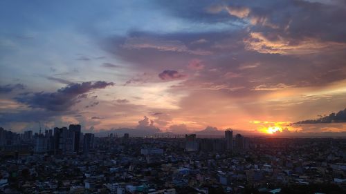 Aerial view of buildings against sky during sunset