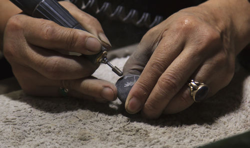 Close-up of hands carving on stone