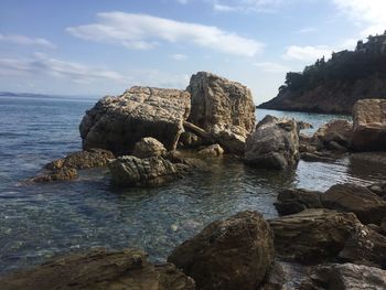 Rocks on sea shore against sky