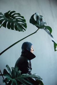 Side view of man looking at plant