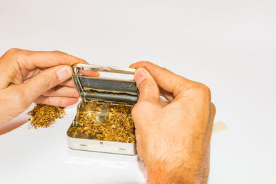 Close-up of hand holding ice cream over white background
