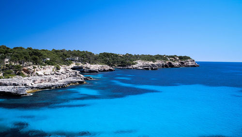 Scenic view of sea against clear blue sky