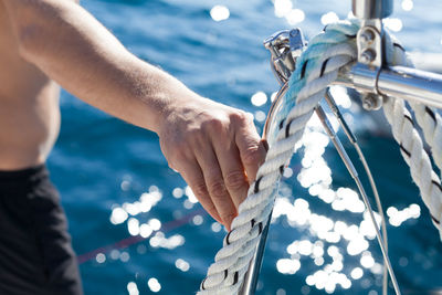 Close-up of hands sailing in sea