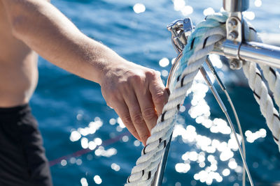 Midsection of man sailing in sea