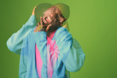 Double exposure of frustrated man against green background