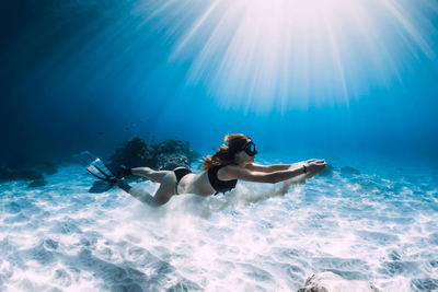 Rear view of woman swimming in sea