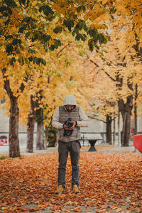 Man standing by leaves during autumn