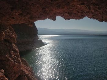 Rock formations by sea against sky