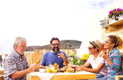 Multi generation family having breakfast on terrace against clear sky