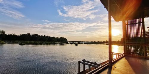 Scenic view of river against sky at sunset