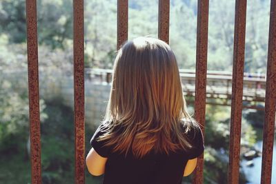 Rear view of girl standing by gate