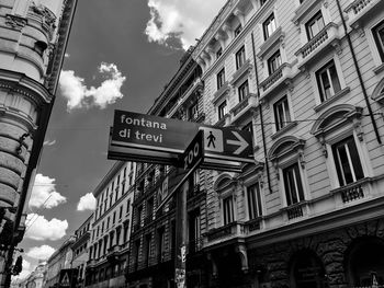 Low angle view of information sign against sky in city