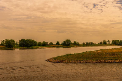 Scenic view of river against sky during sunset