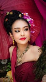 Smiling young woman in traditional clothing standing outdoors