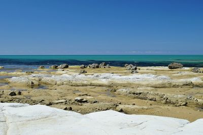 Scenic view of beach against clear blue sky