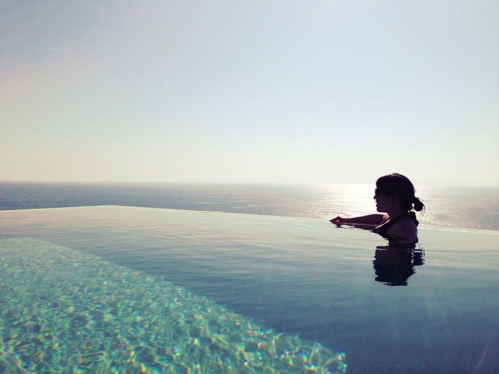 water, horizon over water, sea, lifestyles, leisure activity, full length, clear sky, beach, copy space, childhood, rear view, shore, casual clothing, boys, standing, tranquility, nature, elementary age