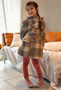 Girl looking away while standing on floor at home