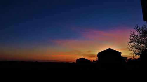 Silhouette buildings against sky during sunset