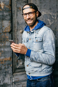 Portrait of smiling young man using mobile phone