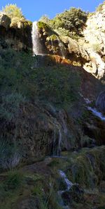 Scenic view of waterfall against sky