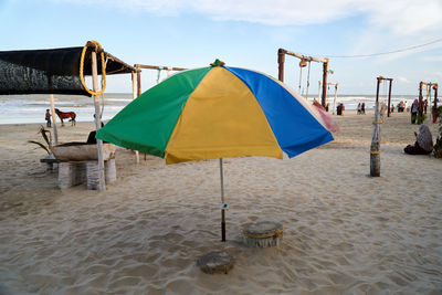 Deck chairs and parasols on beach against sky