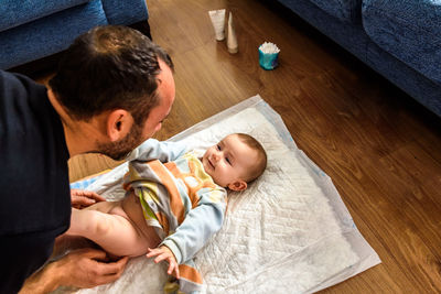 High angle view of father with baby at home