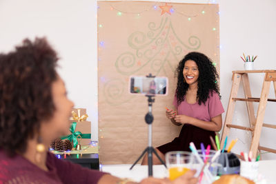 Portrait of smiling young woman standing on table