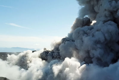 Smoke emitting from volcanic mountain against sky